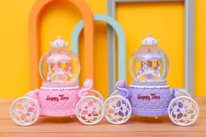 Detailed view of pink and purple carriage carousel music box snow globes with unicorn design.
