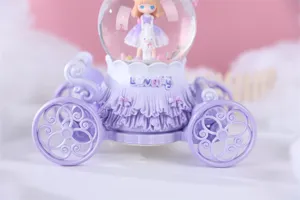 Boule à neige carrosse de princesse violette avec musique et lumières, détail romantique.