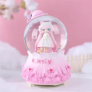 Vue détaillée de la jolie boîte à musique boule à neige rose lolita avec base à volants.