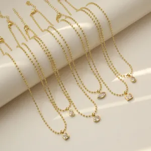 Collane di perle d'oro minimaliste con luminosi ciondoli geometrici in zircone cubico.