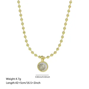 Detailed view of gold beaded chain necklace with round zircon pendant, elegant clavicle chain.