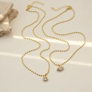Minimalist gold beaded necklace with sparkling zircon pendant, layered chic clavicle chain.