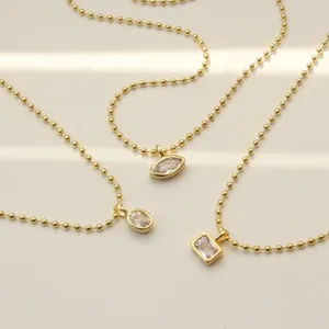 Minimalist gold beaded necklace set with geometric cubic zirconia pendants for women.