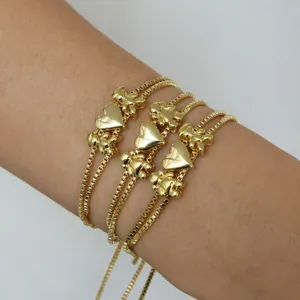 Gros plan détail de bracelets plaqués or avec de charmants pendentifs garçons et filles.