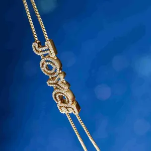 Detailed close-up shot of sparkling rhinestone paved custom letter JOYCE pendant necklace accessory.