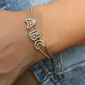 Detailed close-up of a gold-plated initial letter bracelet with sparkling cubic zirconia.