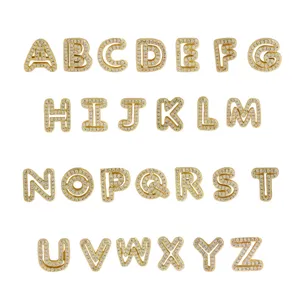 Detailed view of 26 gold-plated brass alphabet charms sparkling with cubic zirconia stones.