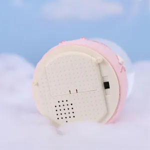 Close-up detail view of the pink snow globe base, showing battery compartment and switch.