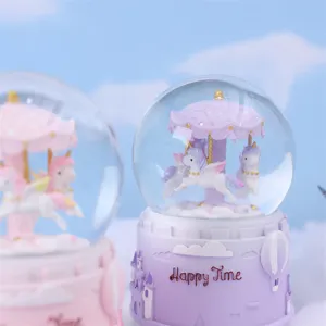 Dettaglio della raffinata palla di neve carosello con unicorni carini e base del castello.