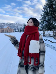 Winterliche Schneekulisse Außendetail eines dicken roten Taschentuchs mit Fransen.