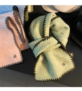 Nahaufnahme des dicken Winterschals mit kontrastierenden Zierstichen und charmanten Kanten.