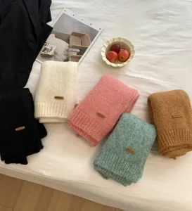Detailaufnahme des weichen Strickschals mit Alpaka-Wollmischung und Lederetikett.
