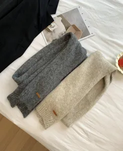 Gemütlicher Alpaka-Mischgewebe Schal mit stilvollem Lederetikett Detail in neutralen Farben.