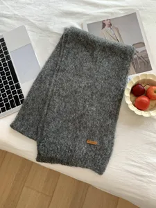 Einfarbiger, kuscheliger Strickschal mit modischem Lederetikett für Damen und Herren im Alltag.