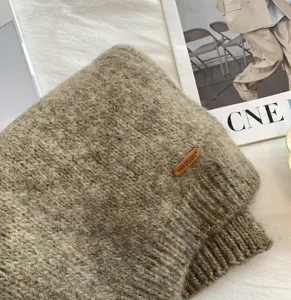 Alpaca Mischung Strickschal Detailansicht mit weicher Textur und Lederetikett Markenzeichen.
