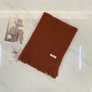 Gemütlicher karamellfarbener Winterschal Detail, weicher Kaschmir-Imitat Stoff mit Fransen.