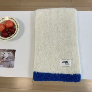 Gemütlicher Winterschal aus Strick mit kontrastierendem blauem Saum und Label.