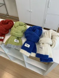 Detailaufnahme bunter Strick-Wollschals mit stilvollem Farbmix und warmem, weichem Material.