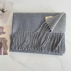 Grauer Winter Schal Detailansicht mit weichem Kaschmirgefuehl und elegantem Fransenrand.