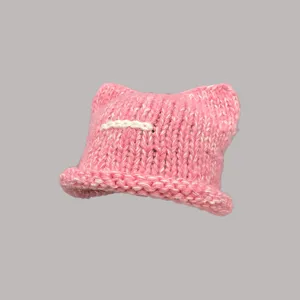 Primo piano del berretto rosa in maglia con orecchie di gatto e dettagli di cucitura.