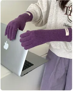 Nahaufnahme der melierten Wollstrickhandschuhe mit weicher Textur und langem Bündchen im Winter.