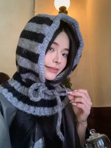 Vista detallada de un cómodo gorro pasamontañas de punto a rayas para mujer en invierno.
