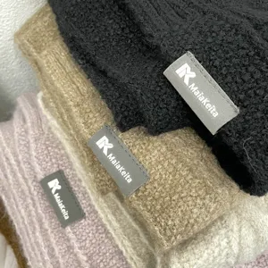 Gros plan détail d'une écharpe en tricot doux avec étiquette de marque, texture cozy.