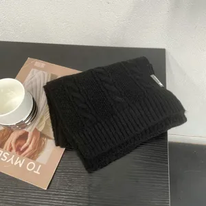 Détail d'écharpe en maille noire, hiver épaisse et chaude accessoire doux unisexe.