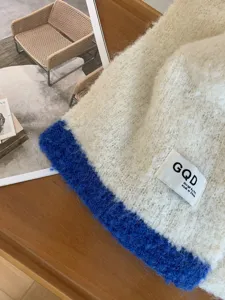 Nahaufnahme des koreanischen Farbmodul-Strickschals mit Wolltextur und Markenetikett.
