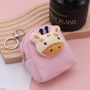 Close up detail of pink mini backpack coin purse with cute plush giraffe decor and metal keyring.