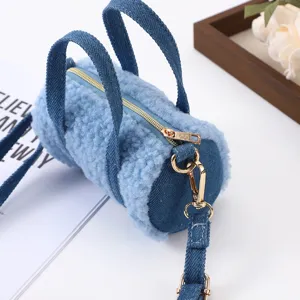 Mini blaue Plüsch Zylinder Umhängetasche mit Jeansgriffen und goldenen Reißverschlüssen.