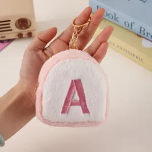 Mini plush letter coin purse keychain, cute pink fuzzy accessory detail view with metal ring.