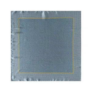 Detailansicht des blauen Seidenschals mit kleinen Punkten und feiner gelber Umrandung.