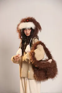 Détail du mignon bonnet à oreillettes chiot duveteux et de son sac en peluche chaud pour l'hiver.