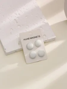 Vue détaillée d'aimants ronds pour hijab blancs, fermeture magnétique sûre pour écharpes.