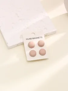 Gros plan détaillé des fermoirs aimantés ronds roses mats pour hijab, texture très délicate.