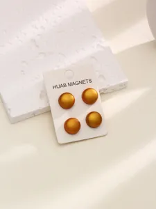 Vue détaillée de pinces à hijab magnétiques rondes dorées sur carte, accessoire foulard.