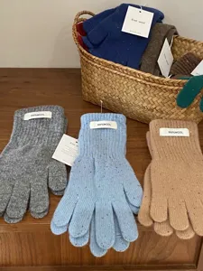 Nahaufnahme von reinen Wollstrick-Fingerhandschuhen in sanften Farben mit weicher Garnstruktur.