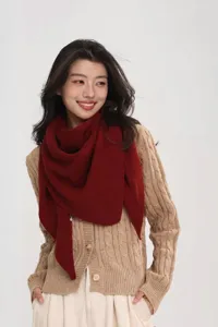 Close-up detail of a dark red knitted triangular scarf, soft warm winter wool accessory.