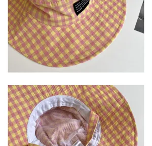 Dettaglio cappello da pescatore a quadretti rosa e giallo con tesa larga e fodera in rete.