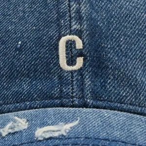 Nahaufnahme Detail der Destroyed Jeans Baseball Cap mit weißer Buchstabe C Stickerei.