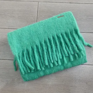 Detailaufnahme mintgrüner dicker Fransen des Wollmisch-Winterschals, weiche Textur