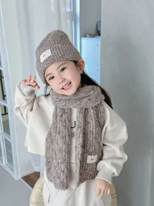 Vista detallada del conjunto de gorro y bufanda de punto suave, textura cálida ideal para el invierno.