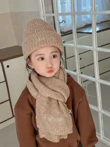 Dettaglio set cappello e sciarpa in maglia per bambini, design ricamato, morbido e caldo.