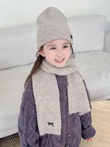 Gemütliches Kinder Strickmütze und Schal Set mit hübscher schwarzer Schleife für den Winter.