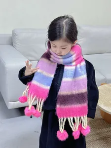 Charmanter bunter Kinder-Winterschal Detail mit kuscheligen Pom-Poms und warmer Textur.