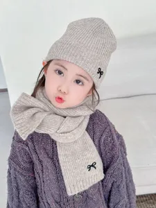 Nahaufnahme Detailansicht des Kinder Strickmützen und Schal Sets mit süßer Schleifenstickerei.