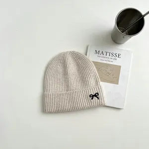Detailansicht der kuscheligen Strickmütze mit feiner schwarzer Schleifenstickerei, warme Mütze.