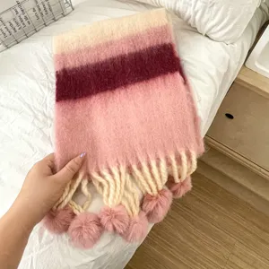 Detailansicht des bunten gestreiften Kinder-Winterschals mit flauschigen Bommel-Quasten.