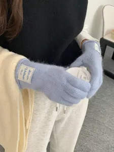 Dettaglio di guanti invernali da donna in maglia touch, design caldo blu tinta unita a cinque dita.